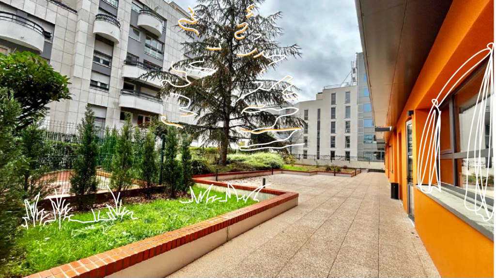 Cour extérieure végétalisée bordée de jardinières, le long d’un bâtiment à la façade orange