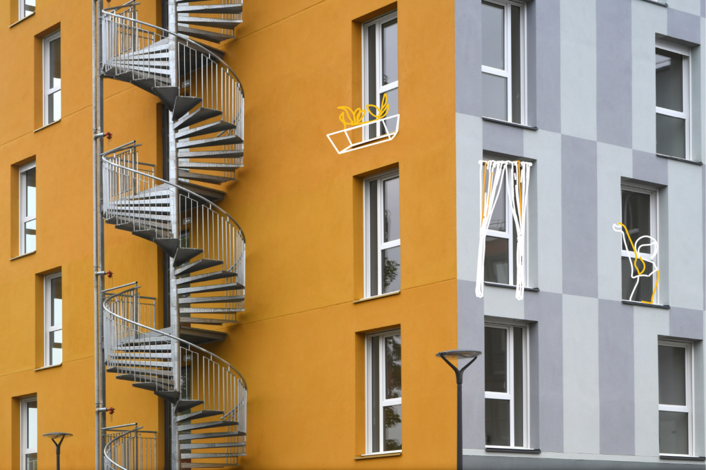 Façades jaune et grise d’un immeuble à Villeneuve-d’Ascq, avec escalier extérieur et dessins aux fenêtres