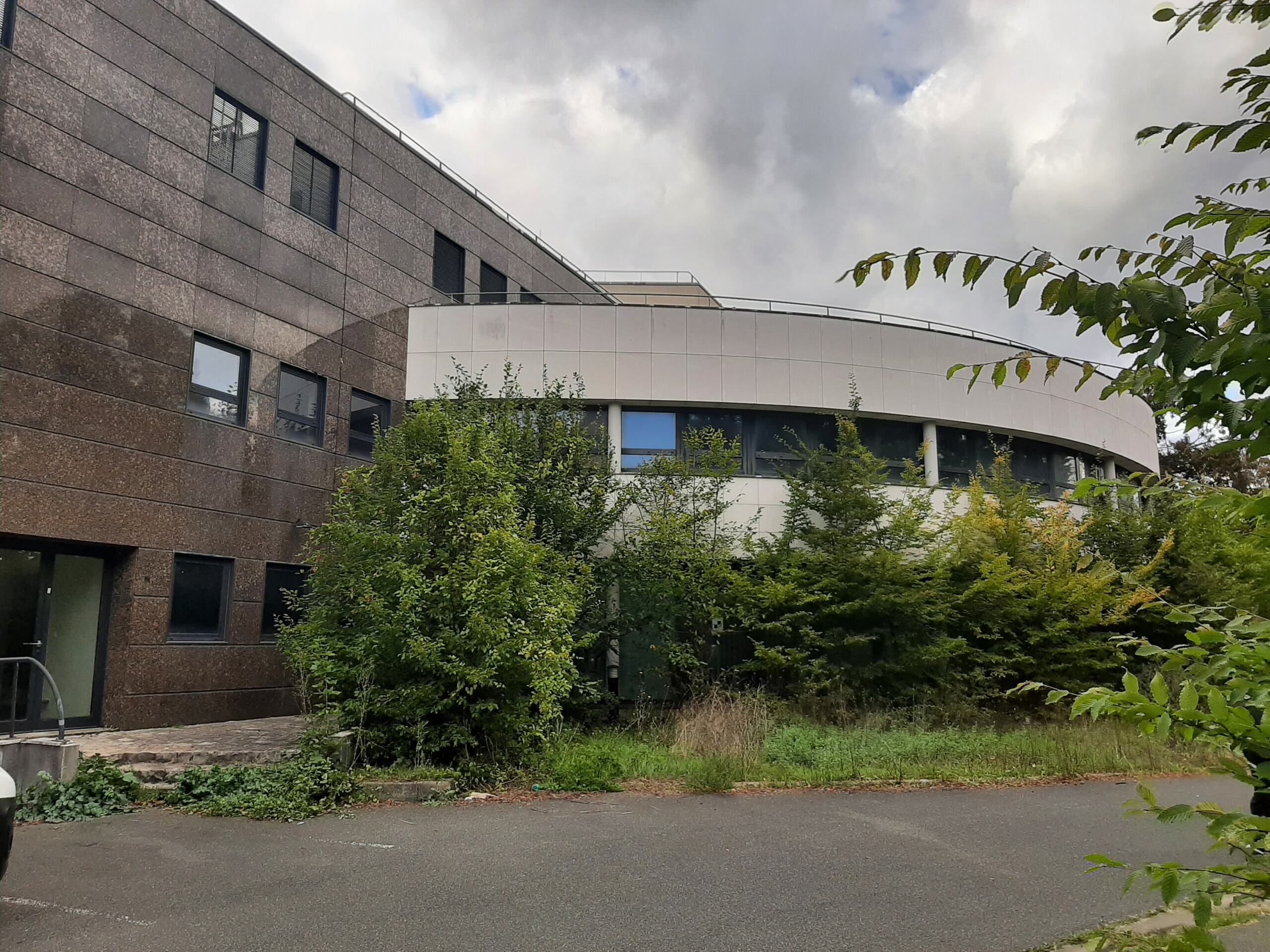 Bâtiment Chantemerle vu de l’extérieur avant travaux, avec façade courbe et végétation