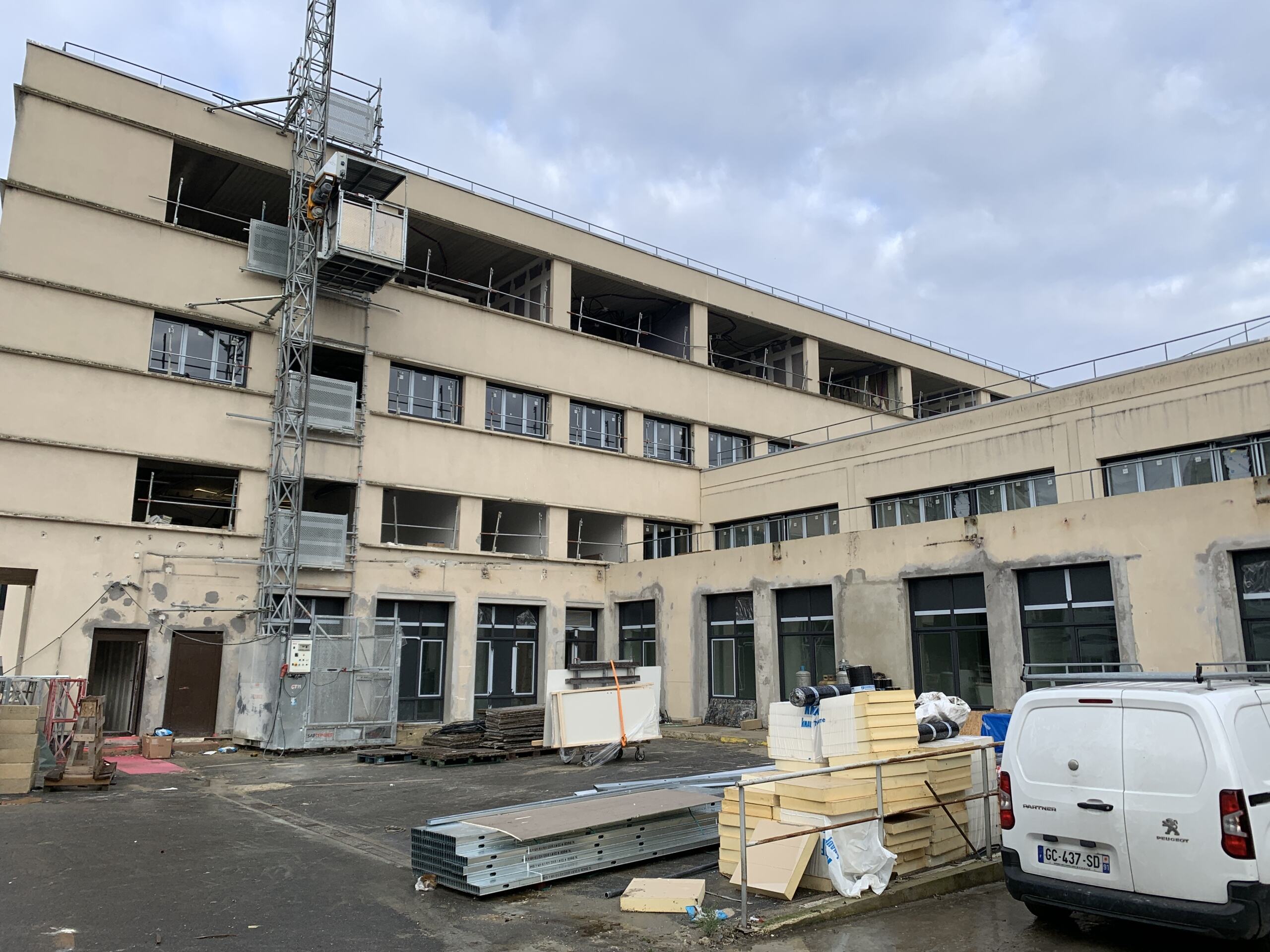 Chantier de rénovation de Chantemerle, façade du bâtiment et matériaux stockés dans la cour