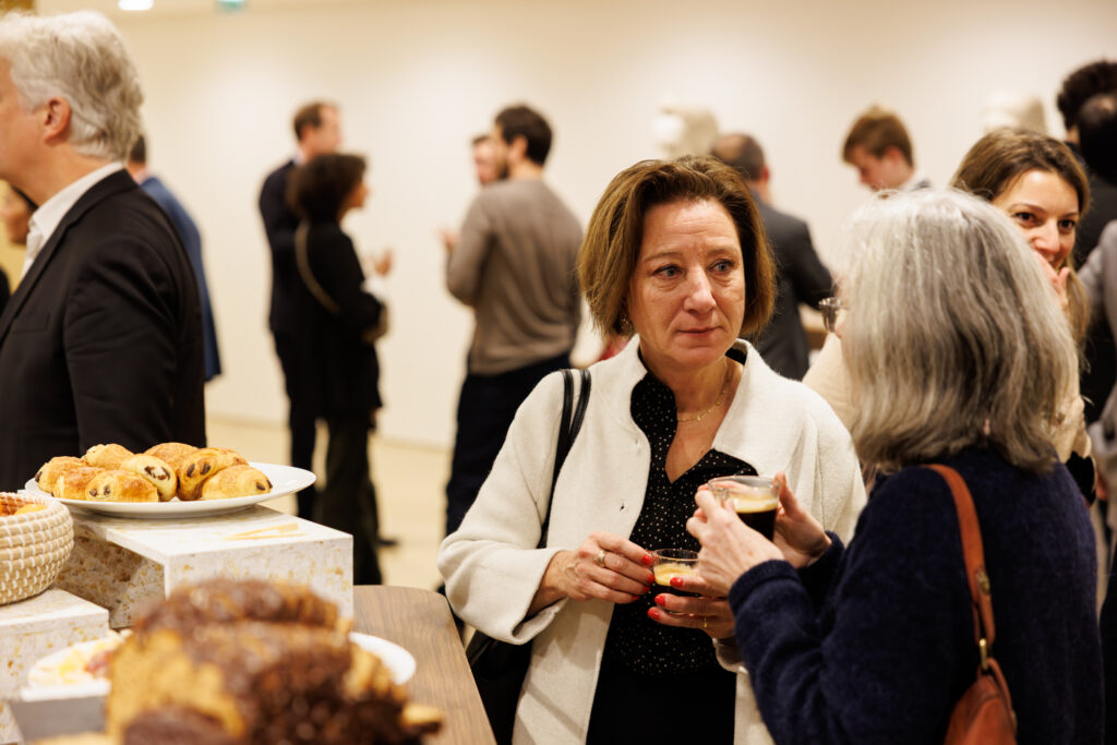 Deux participantes échangent près du buffet lors du Sommet de la Transformation à Paris, en novembre 2025