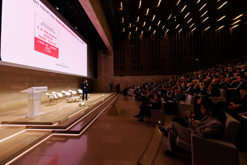 Conférencier sur scène face au public du Sommet de la Transformation au 3 Mazarium à Paris, en novembre 2025