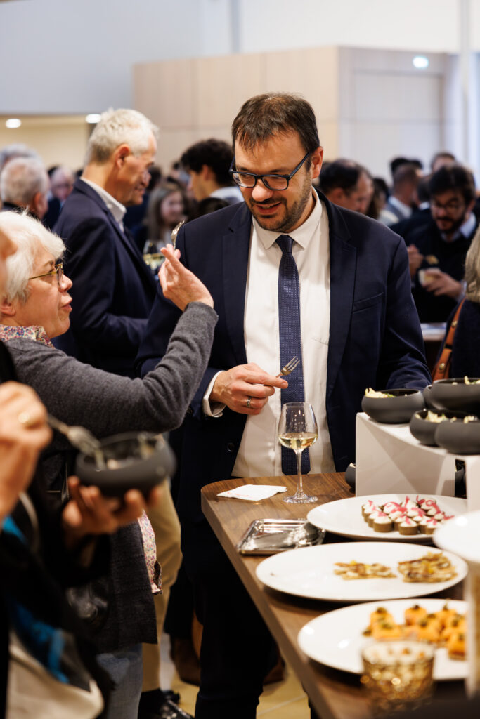 Participant échangeant près du buffet au Sommet de la Transformation au 3 Mazarium à Paris, en novembre 2025