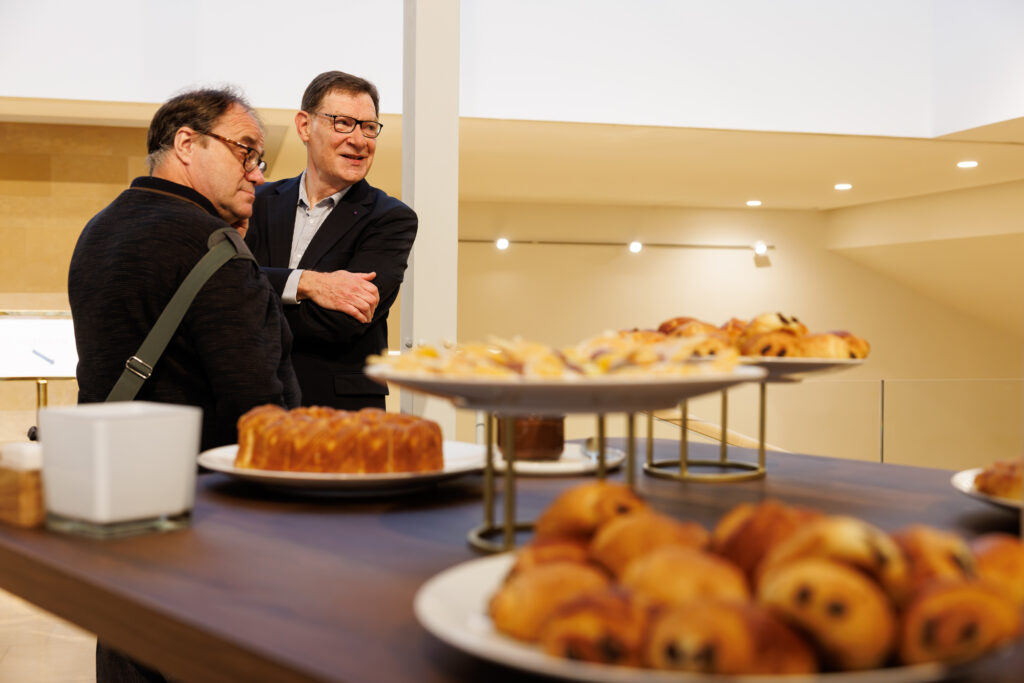 Deux participants échangeant près du buffet au Sommet de la Transformation à Paris, en novembre 2025