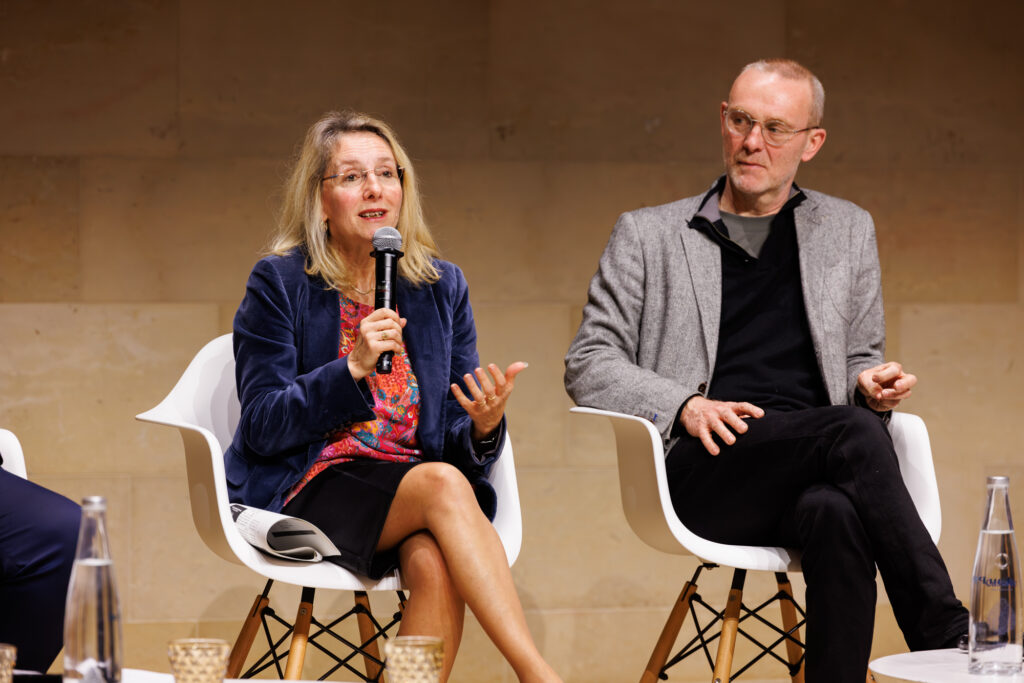 Intervenante prenant la parole aux côtés d’un participant au Sommet de la Transformation à Paris, en novembre 2025