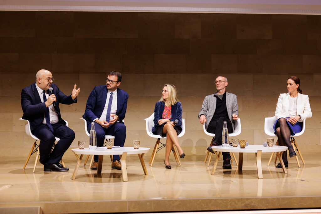 Cinq intervenants en table ronde au Sommet de la Transformation à Paris, en novembre 2025