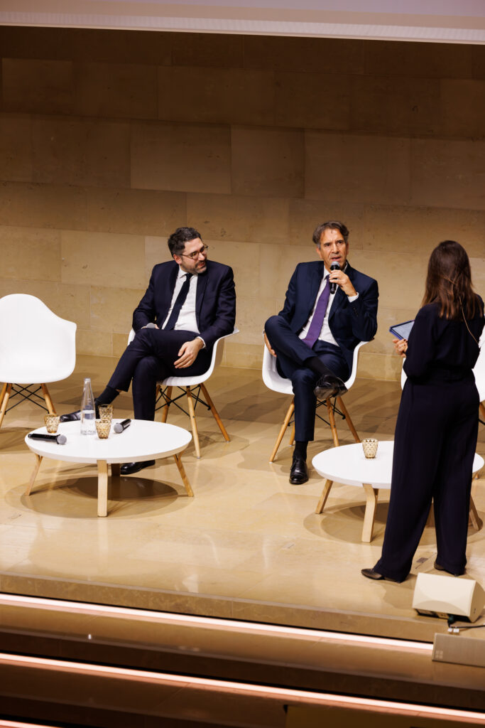 Deux intervenants face à une modératrice au Sommet de la Transformation à Paris, en novembre 2025