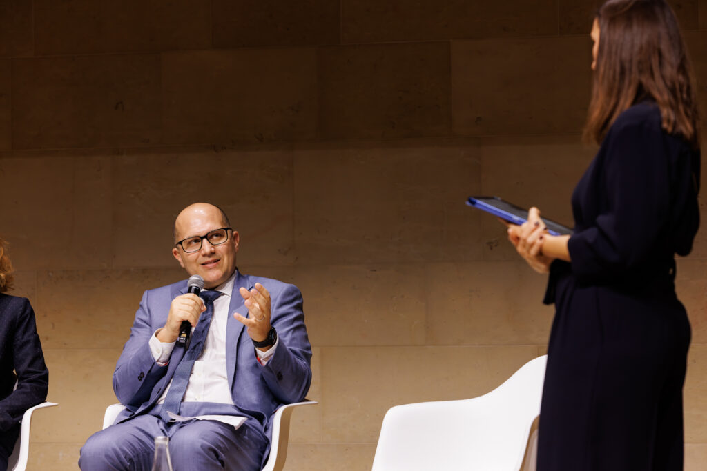 Un intervenant prend la parole face à une modératrice au Sommet de la Transformation à Paris, en novembre 2025