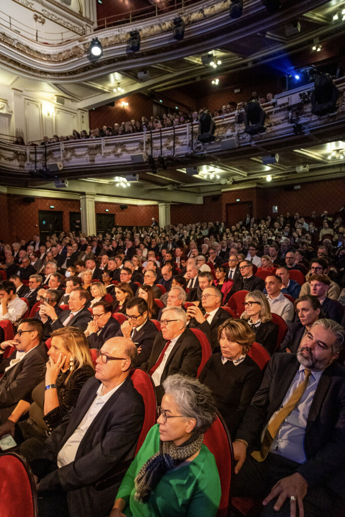 Public nombreux réuni dans une salle de théâtre lors d’une cérémonie de vœux
