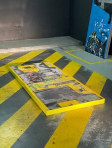 Panneau peint aux motifs jaunes et noirs posé au sol dans un atelier à République, en février 2026