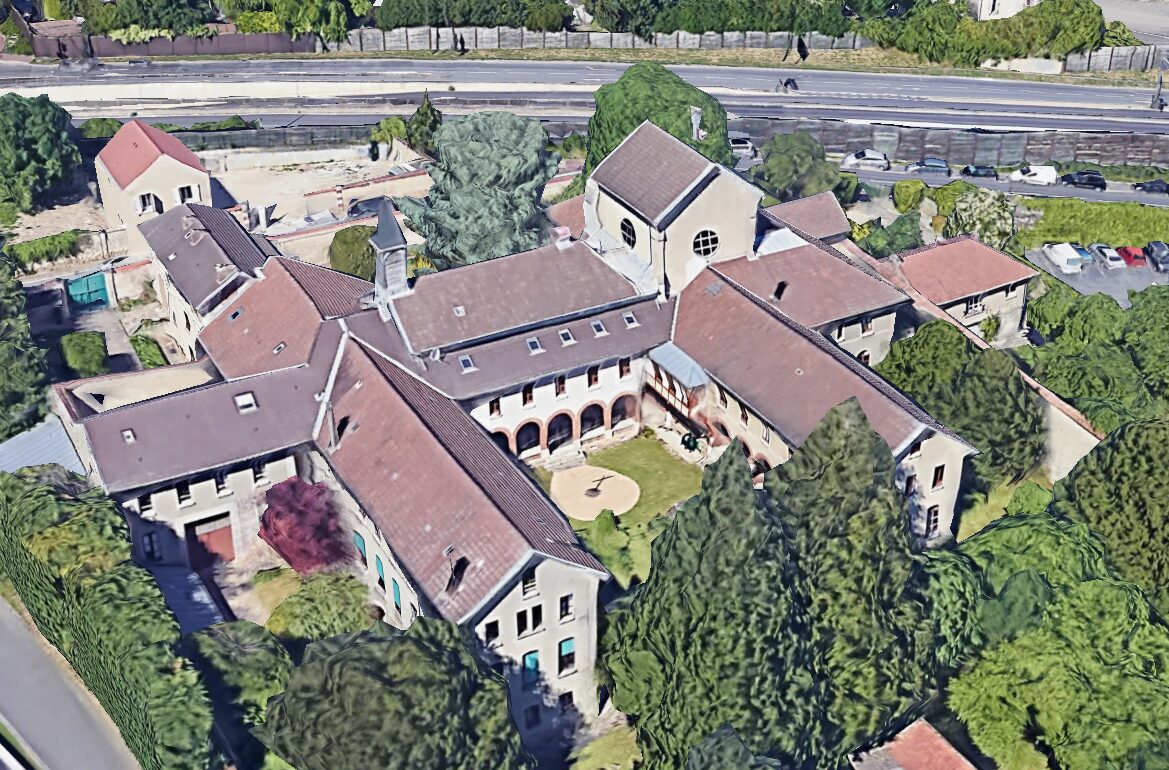 Vue aérienne du Jardin des Carmes et de ses bâtiments à toiture en tuiles autour d’une cour, en mars 2026
